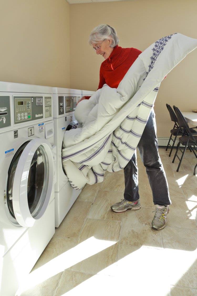woman pulling sheets out of dryer