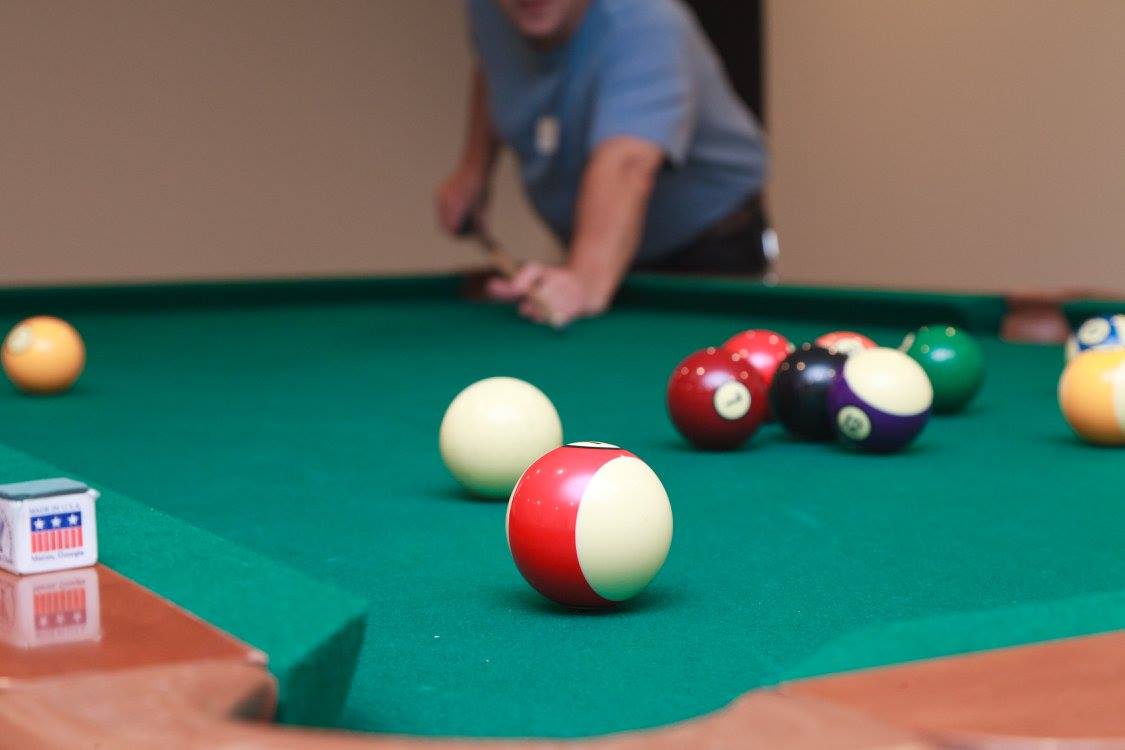man lining up a shot on a pool table